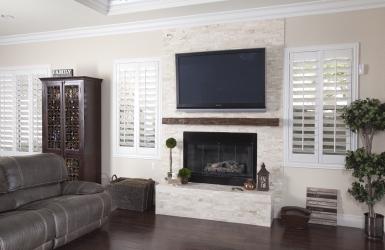 White plantation shutters in a Chicago living room with plank hardwood floors.